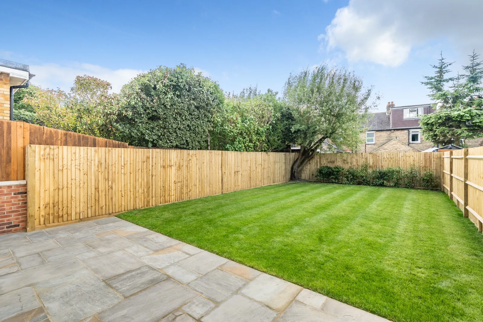 a backyard with a wooden fence and green grass
