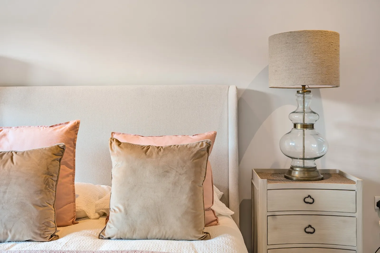 a bed with two pillows and a lamp on top of it