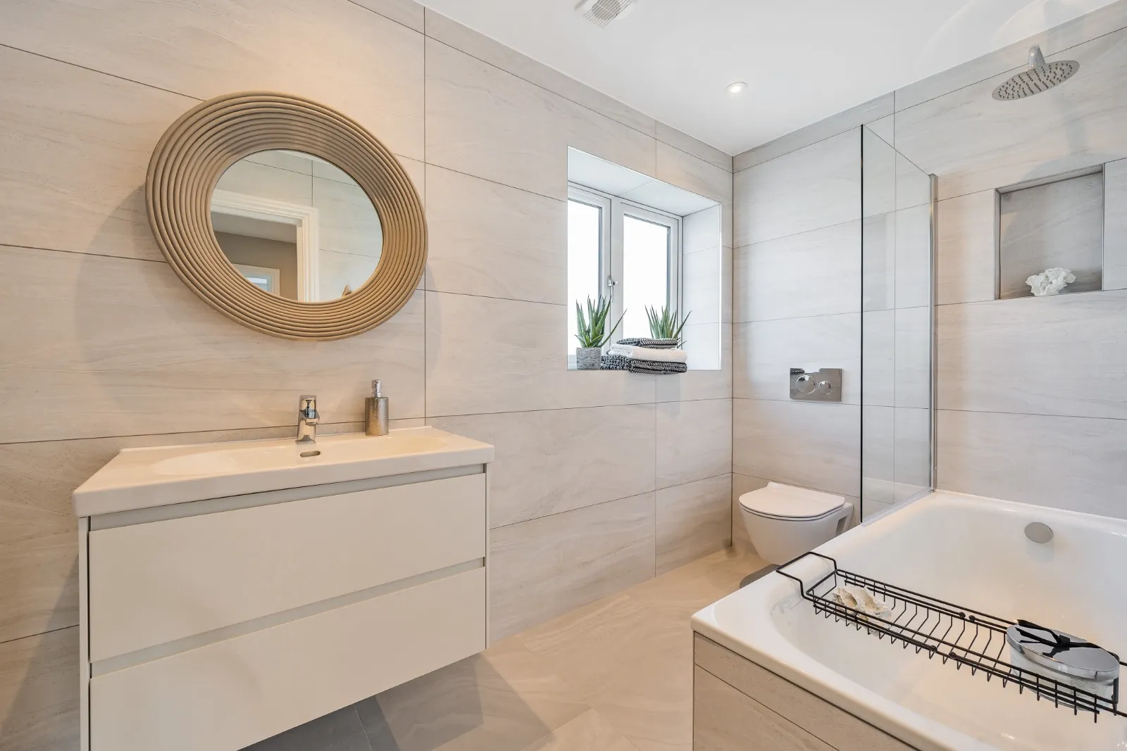 a bathroom with a tub, sink, and mirror