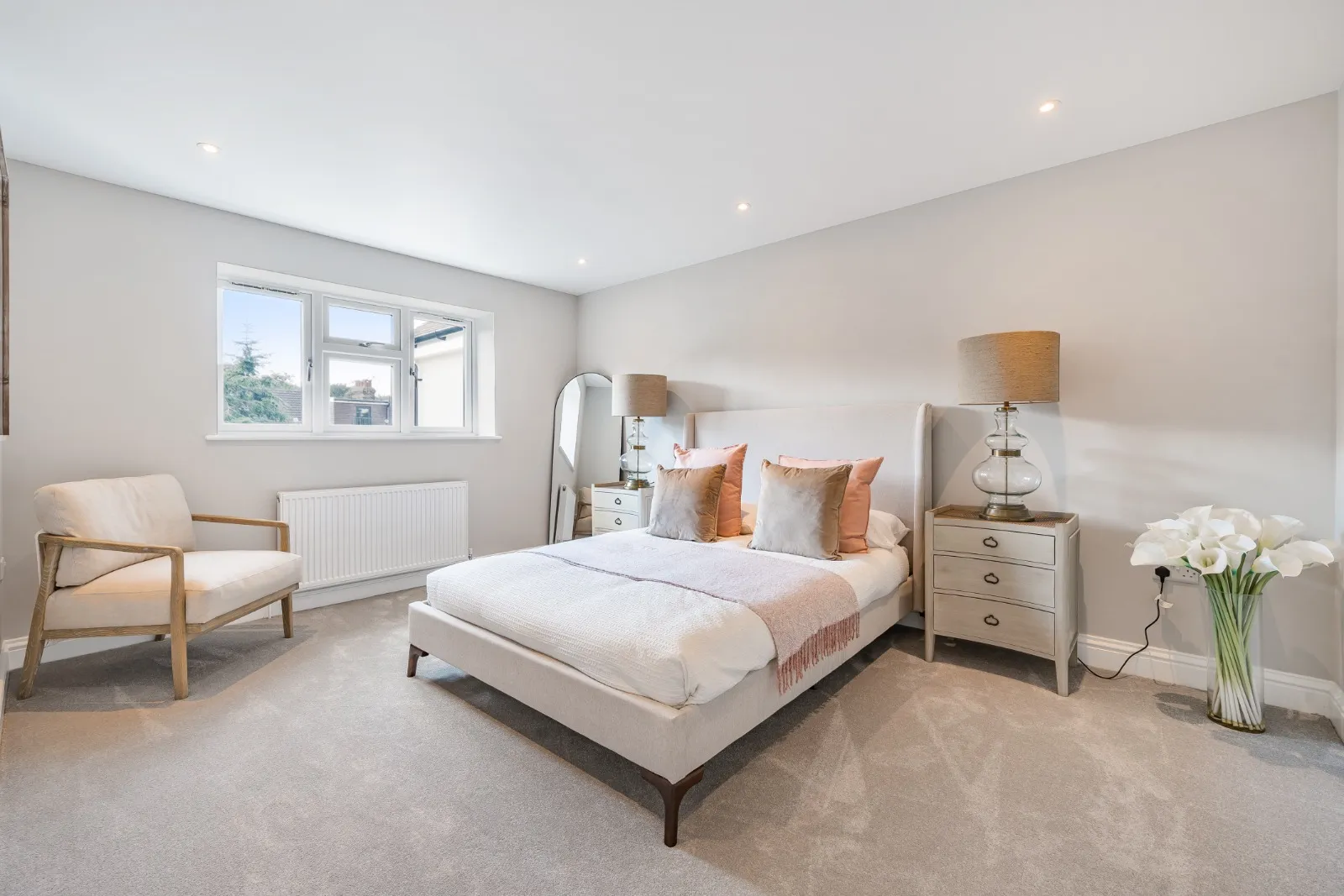 a bedroom with a large bed and a chair