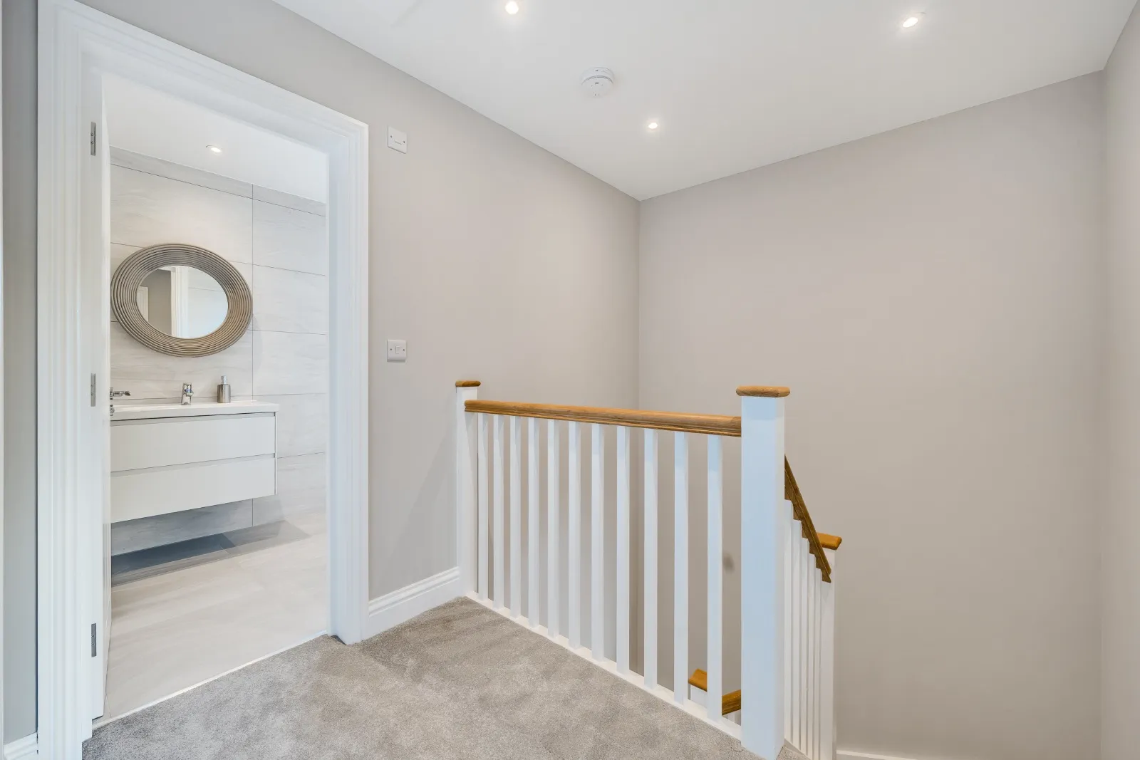 a white staircase with a mirror on the wall