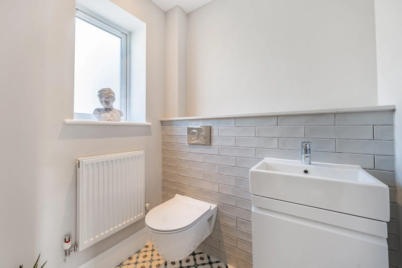 a bathroom with a toilet, sink, and radiator